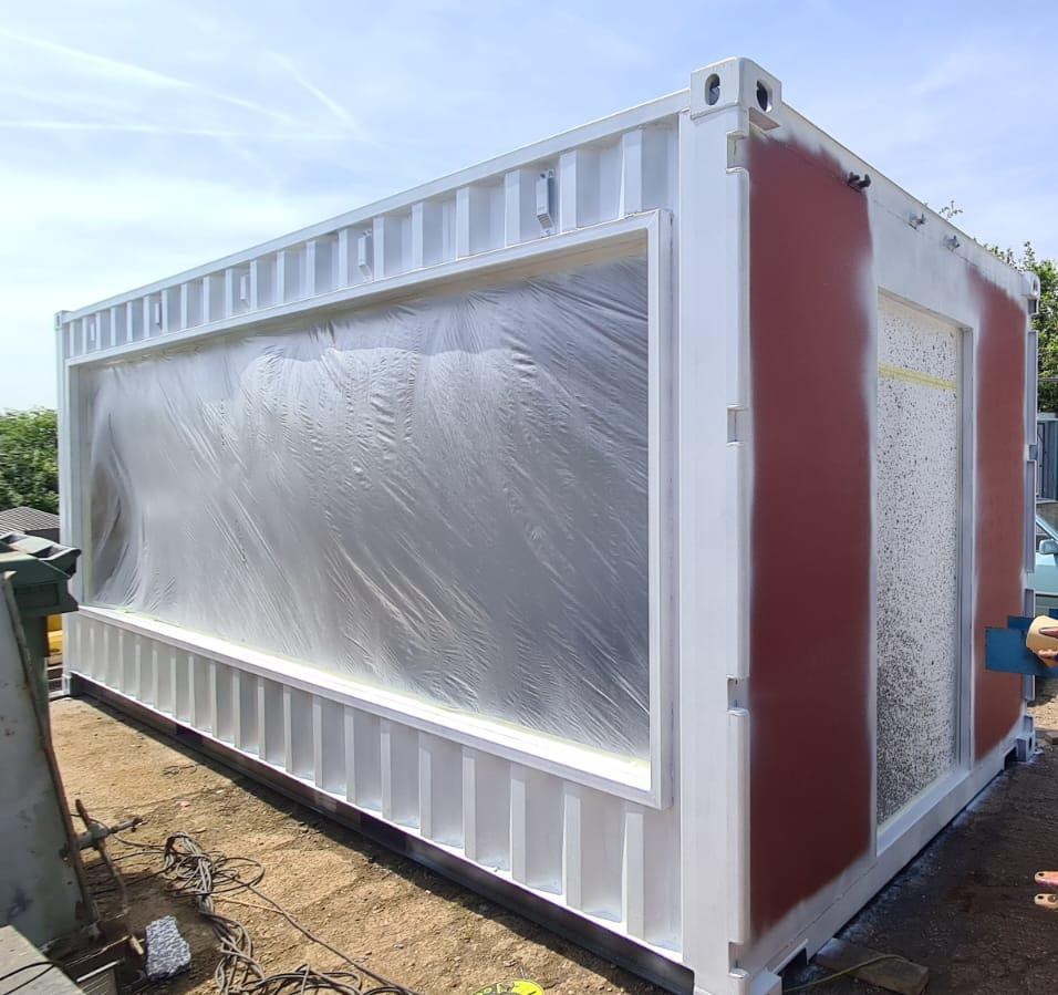 Shipping container with serving hatch reinforcement during fabrication