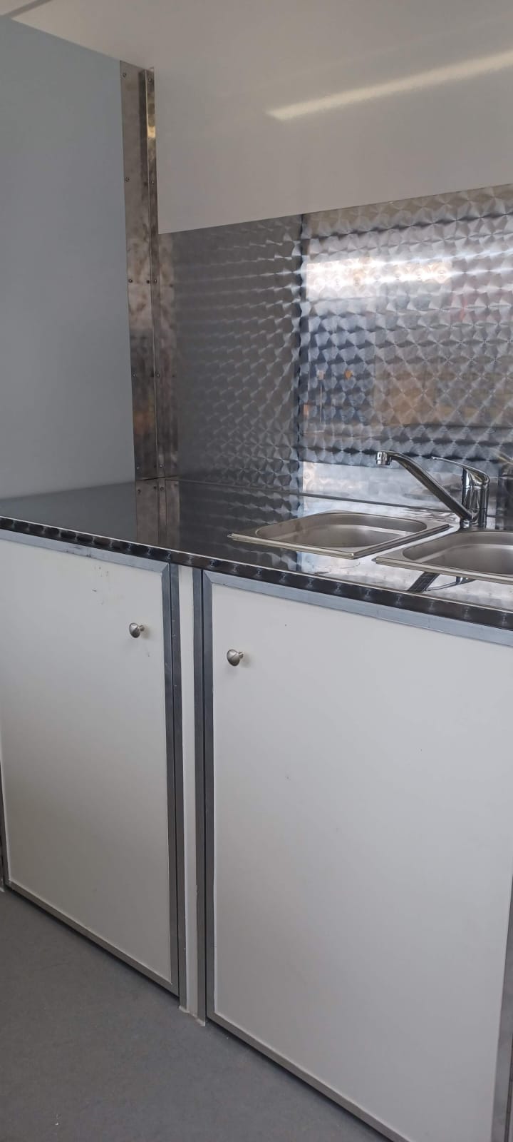 Modern kitchen with stainless steel backsplash and countertops.