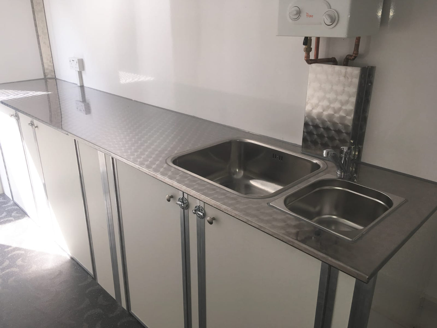 Stainless steel kitchen sink and countertop in a compact space
