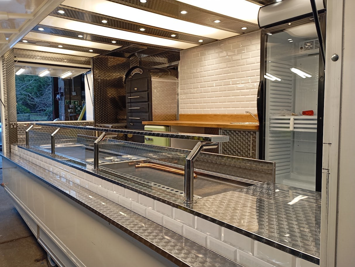 Showman style catering trailer interior with glass display and illuminated ceiling