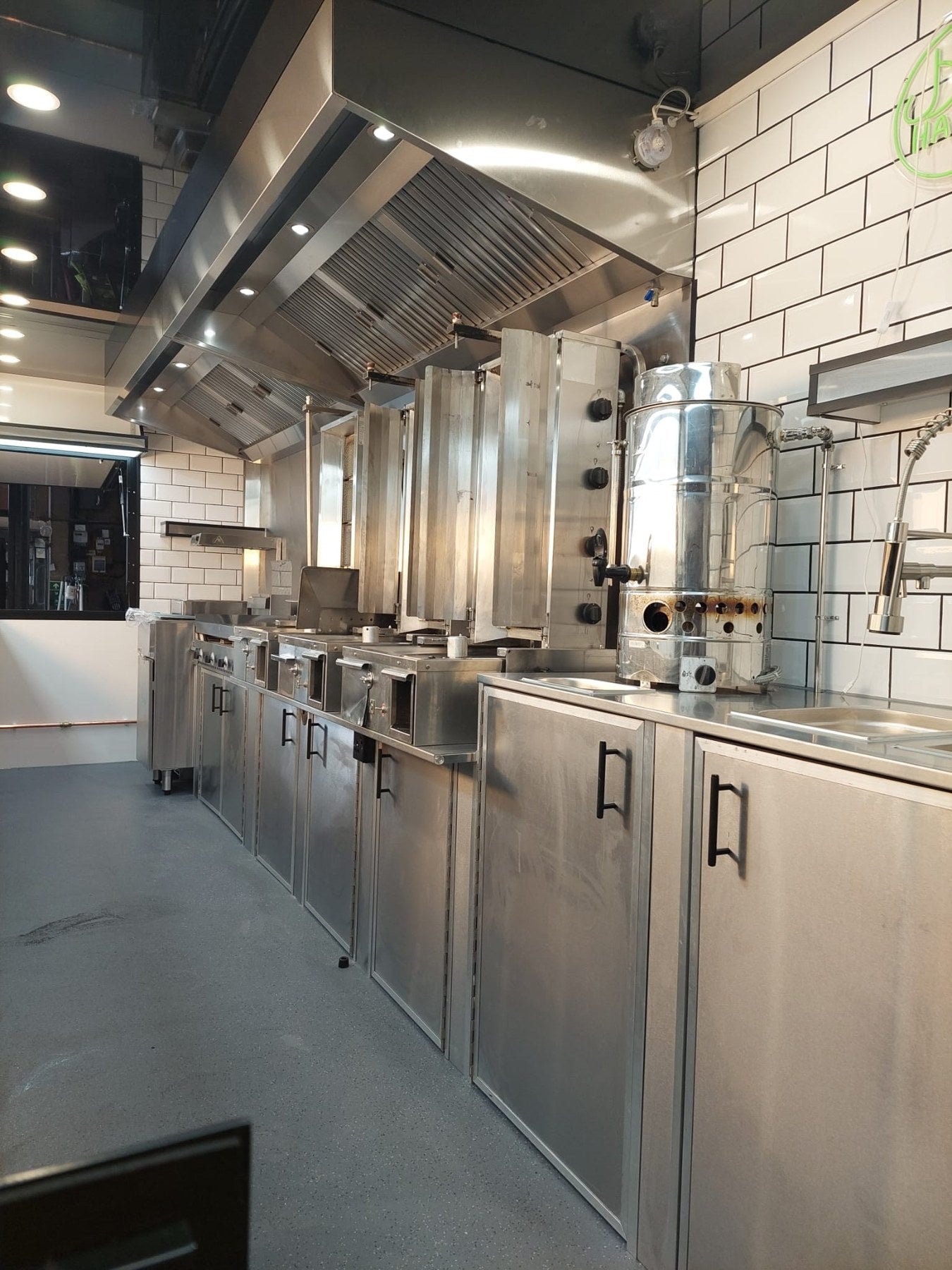 Stainless steel catering trailer kitchen with cooking canopy and tiled walls