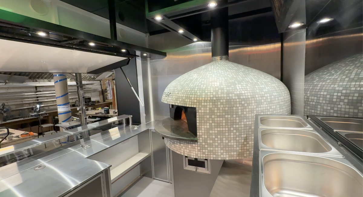 Modern kitchen with a pizza oven and stainless steel appliances