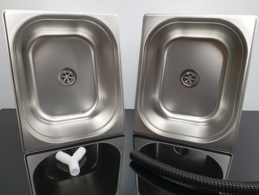 Two stainless steel sinks on a reflective surface with a neutral background